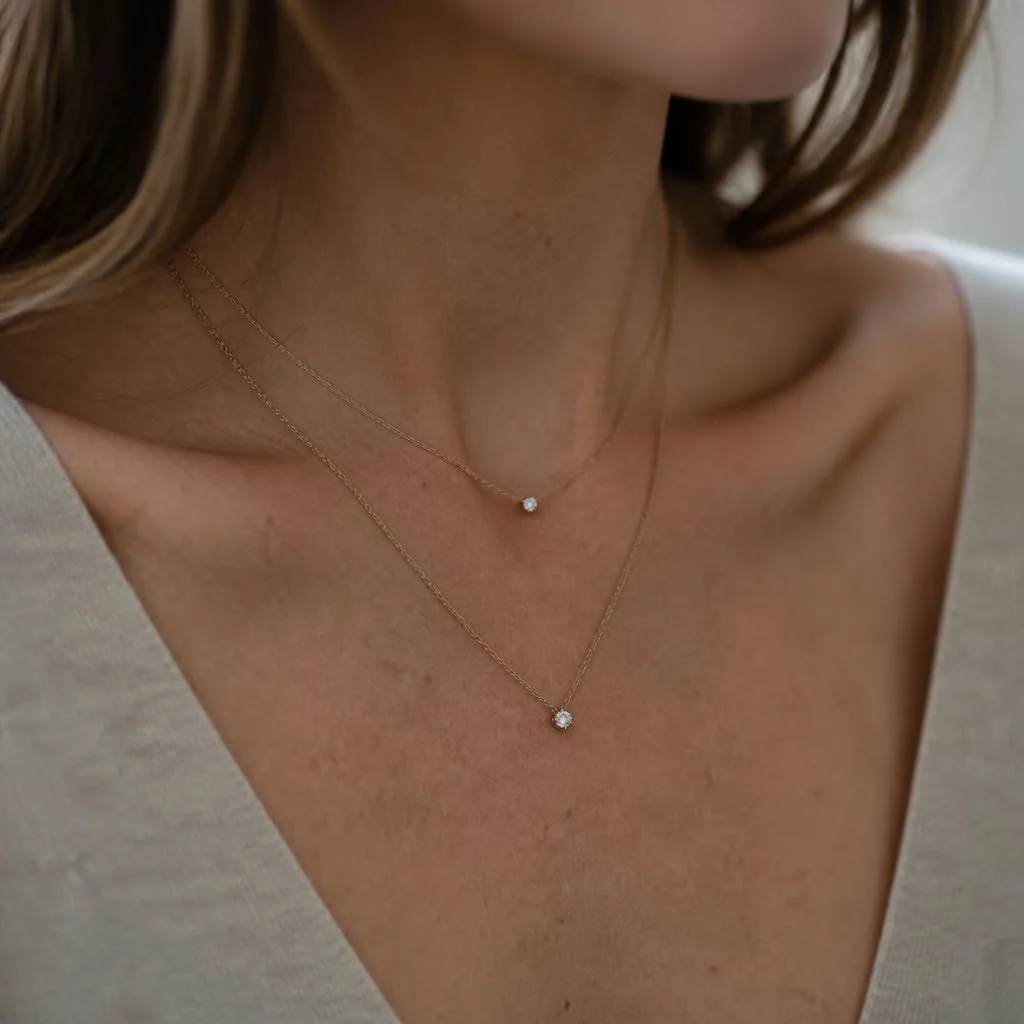 Layered fine diamond necklaces worn at the neckline